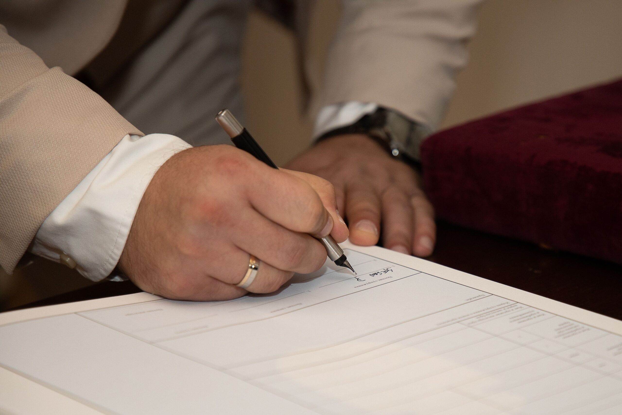 Hand signing a business contract, representing the range of commercial agreements suited for mediation